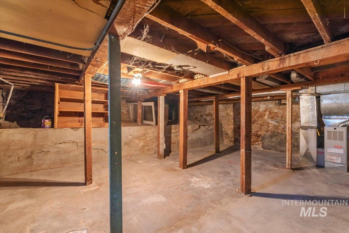 Unfinished basement featuring heating unit