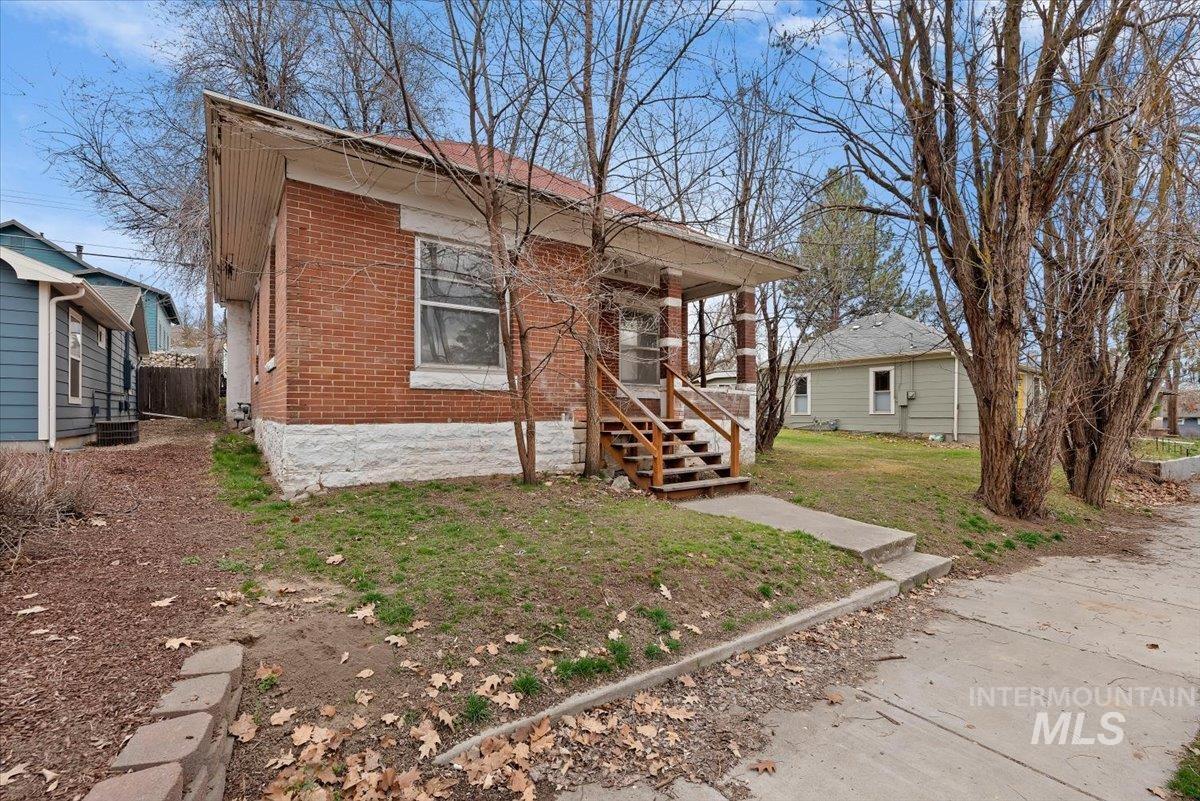 Bungalow-style house featuring brick siding and a front yard