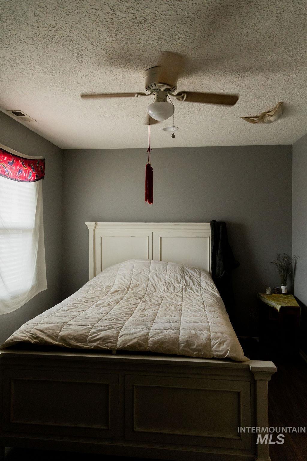 Bedroom featuring a textured ceiling and a ceiling fan