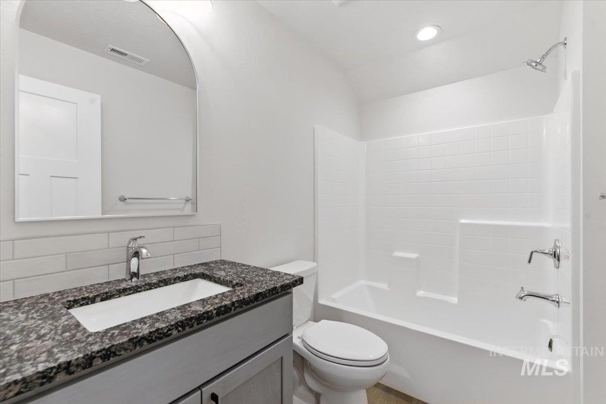 Full bathroom with vanity, tasteful backsplash, and shower / washtub combination