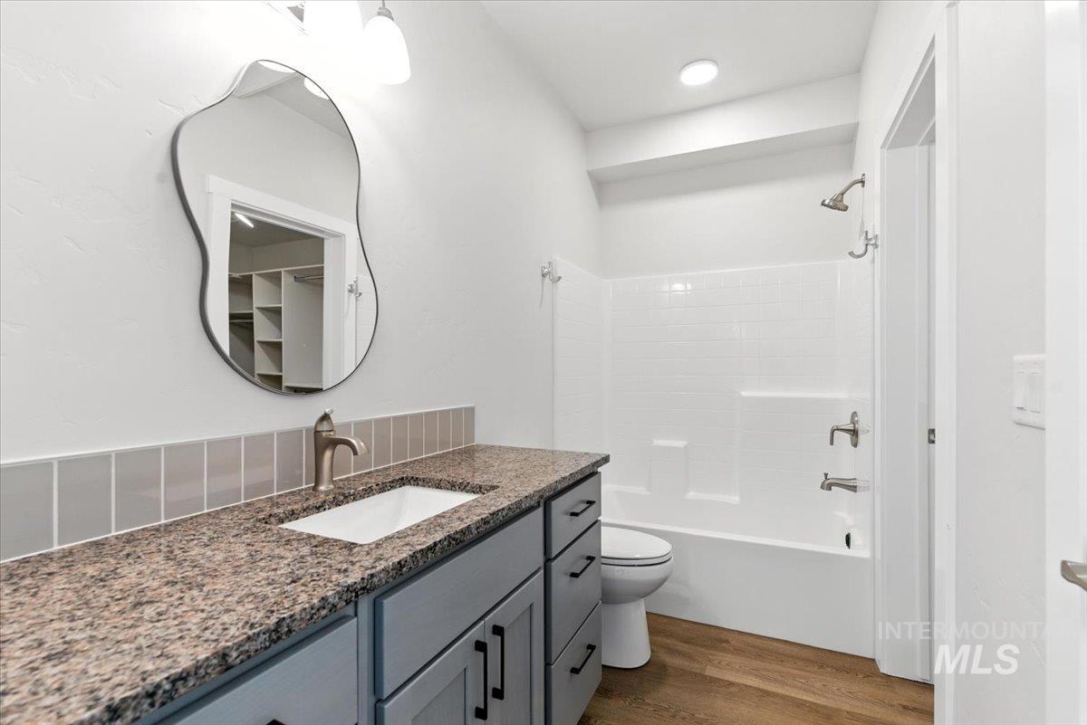 Bathroom featuring vanity, wood finished floors, and bathtub / shower combination