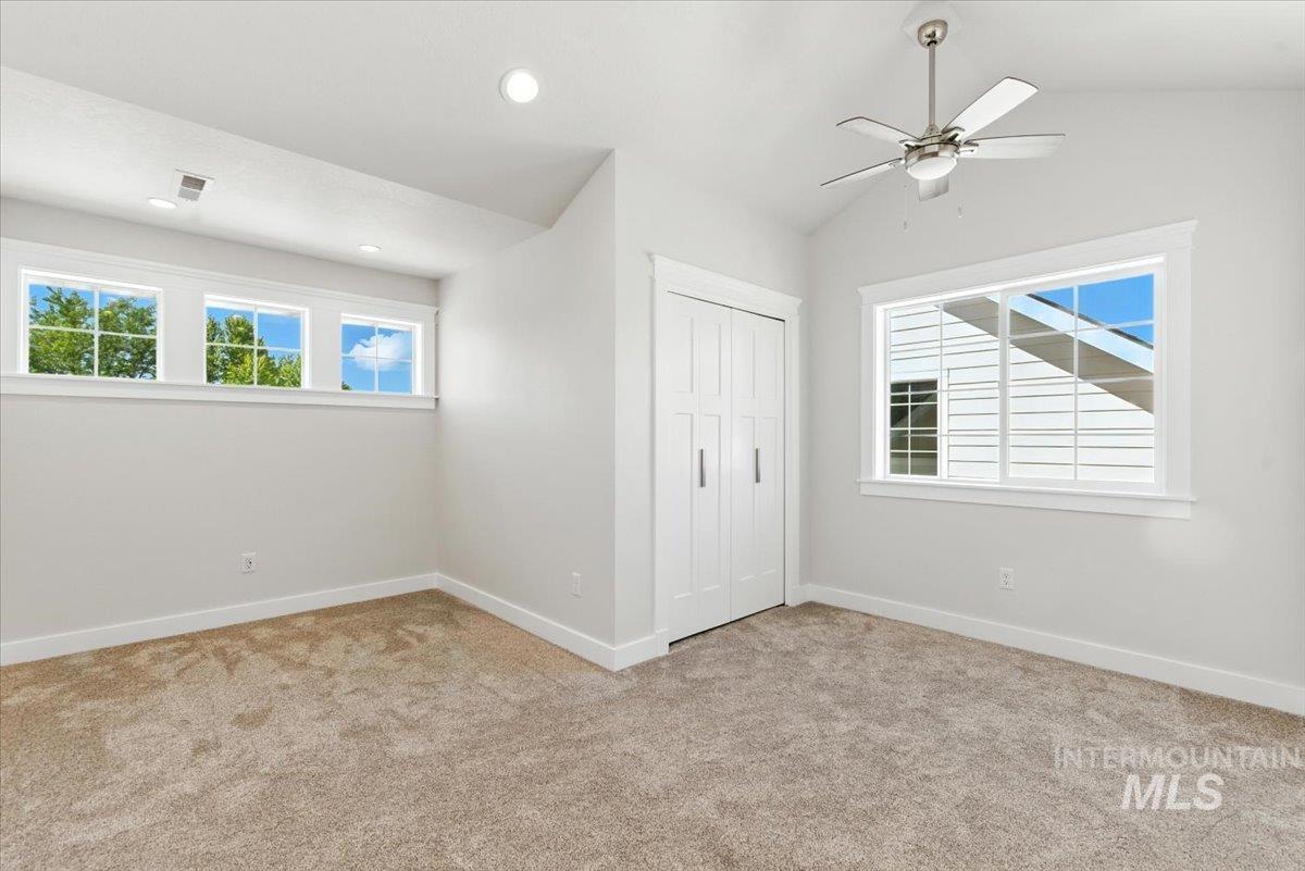 Unfurnished bedroom featuring carpet floors, a closet, recessed lighting, lofted ceiling, and ceiling fan