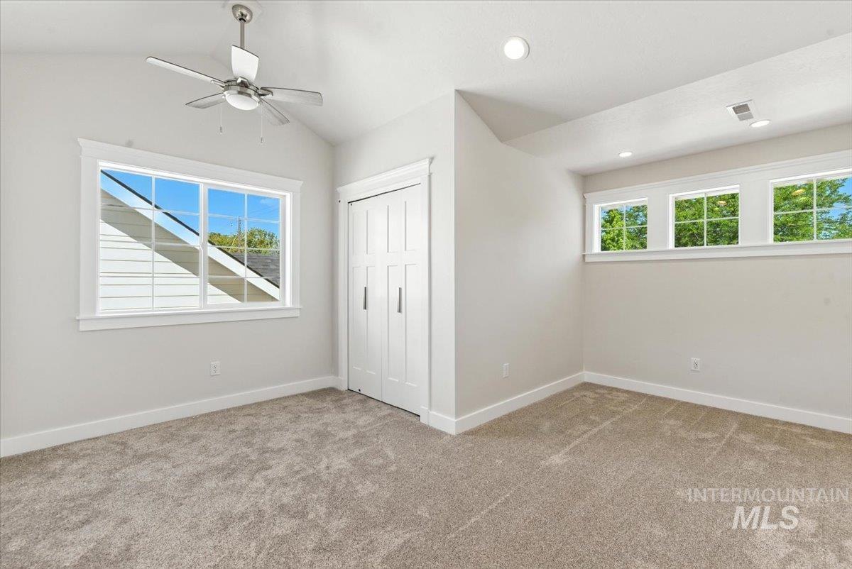 Unfurnished bedroom with carpet flooring, a closet, lofted ceiling, recessed lighting, and ceiling fan