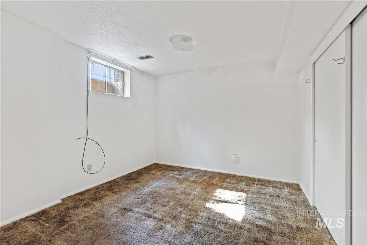 Below grade area with carpet and a textured ceiling