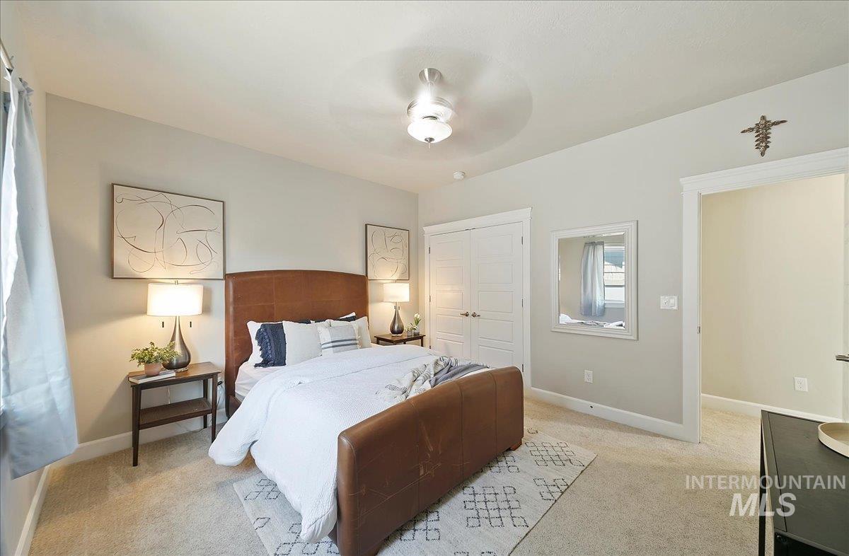 Bedroom featuring light carpet, a closet, and ceiling fan