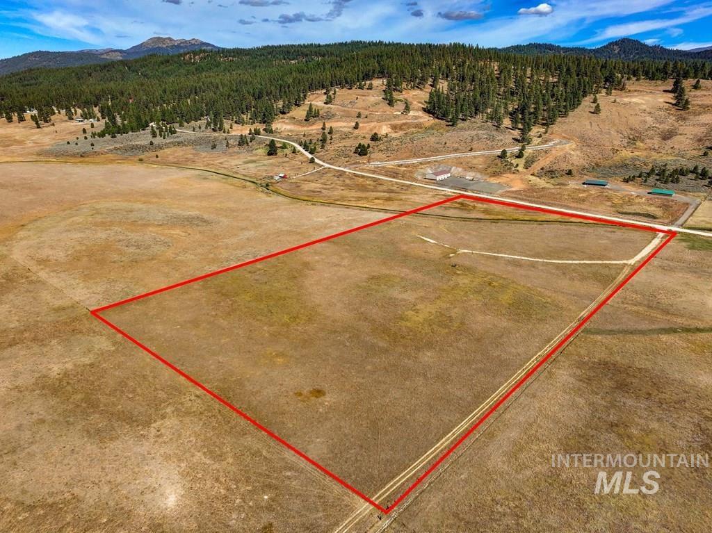 Aerial view of property and surrounding area with mountains and property boundaries highlighted