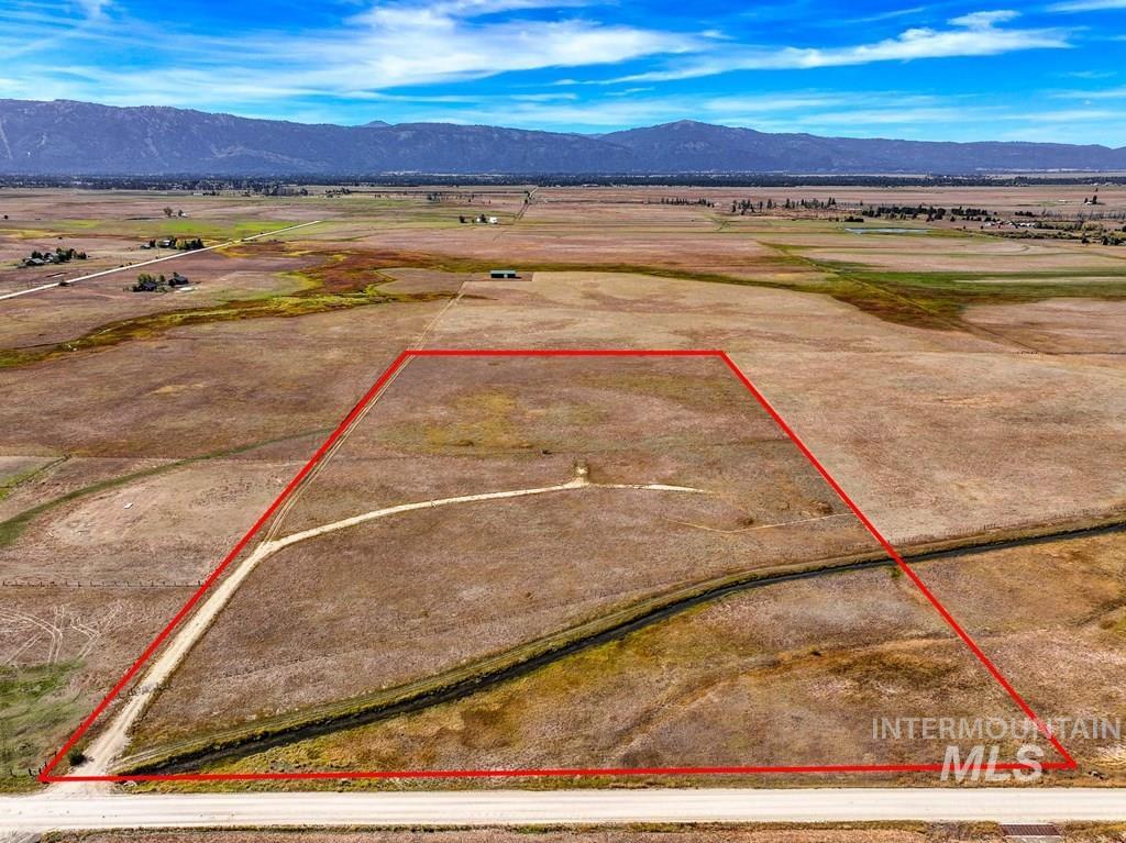 Aerial view of property and surrounding area featuring a mountain backdrop and property boundaries highlighted