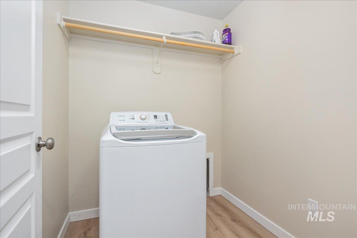 Laundry area with washer / clothes dryer and light wood-type flooring