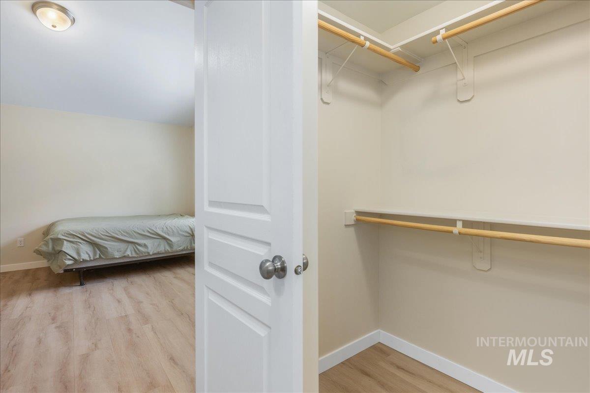Walk in closet featuring light wood-style flooring