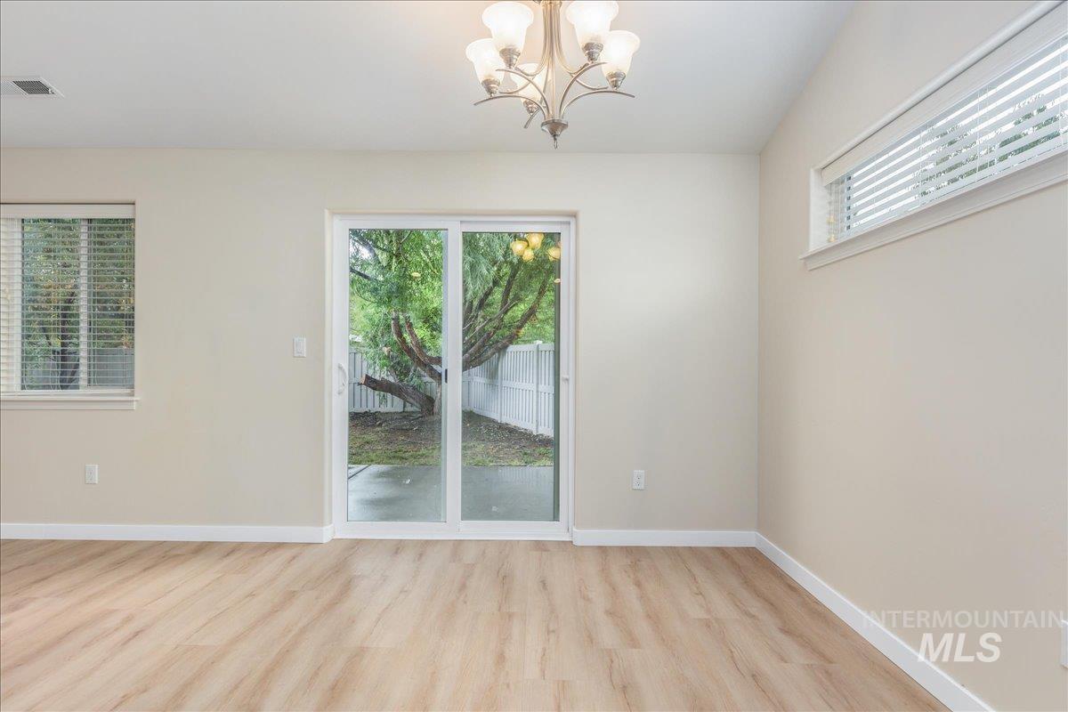 Unfurnished dining area with light wood-style flooring and a chandelier
