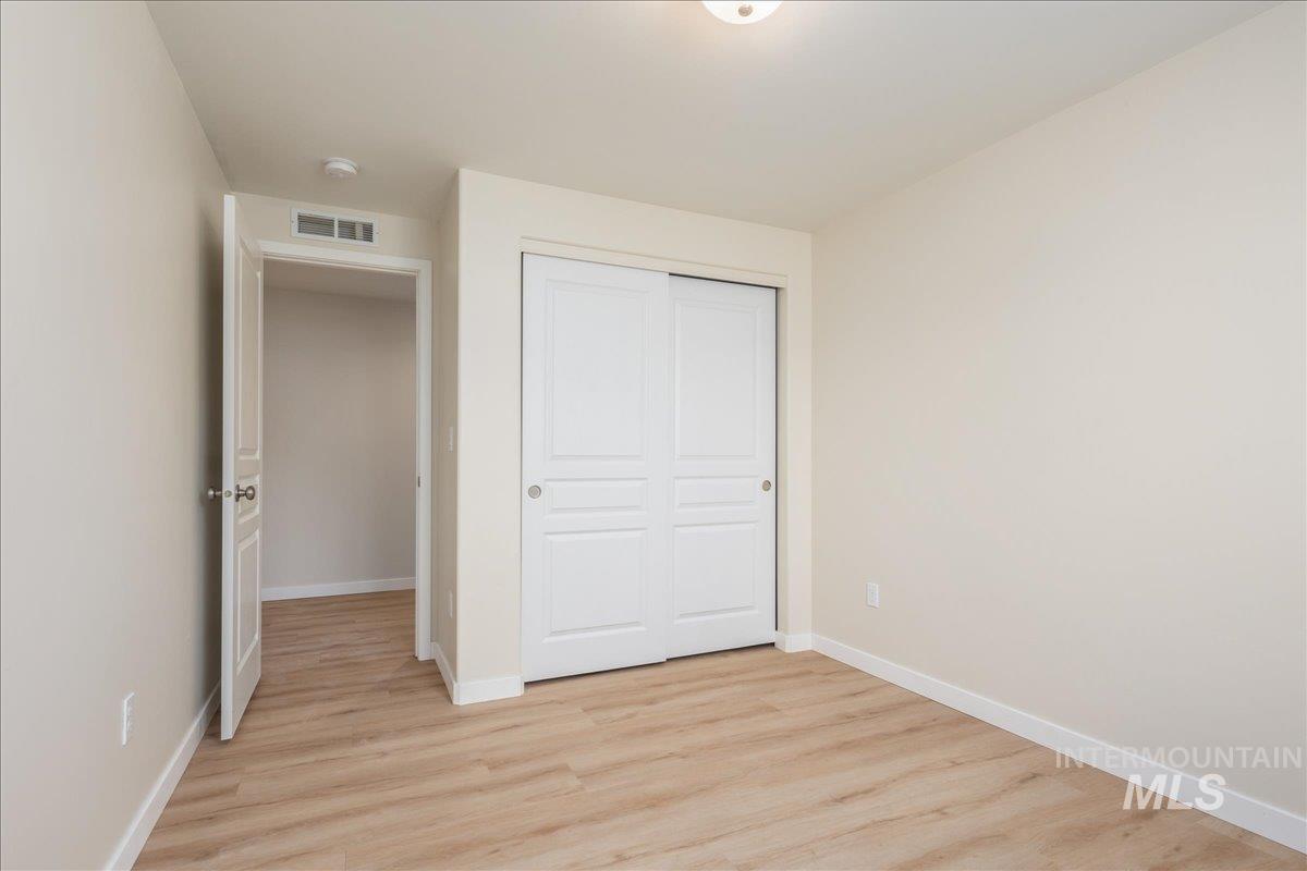 Unfurnished bedroom featuring light wood-type flooring and a closet