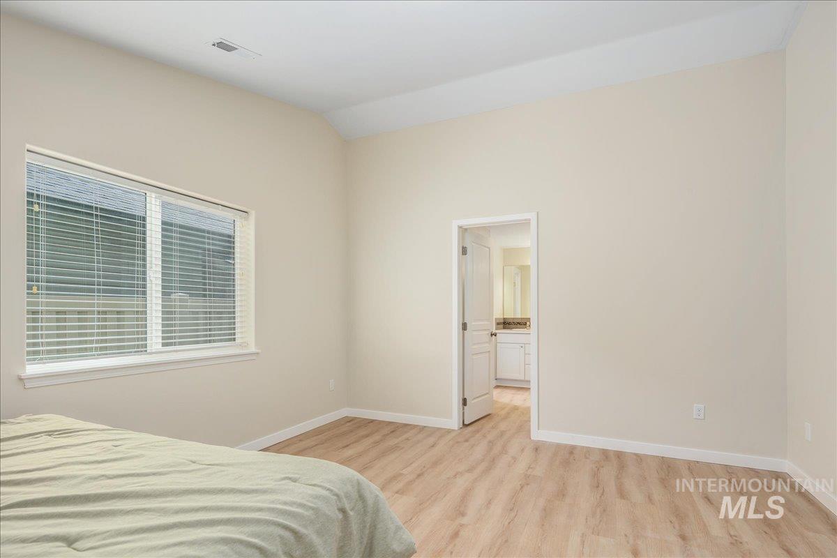 Bedroom featuring light wood-style floors and ensuite bathroom