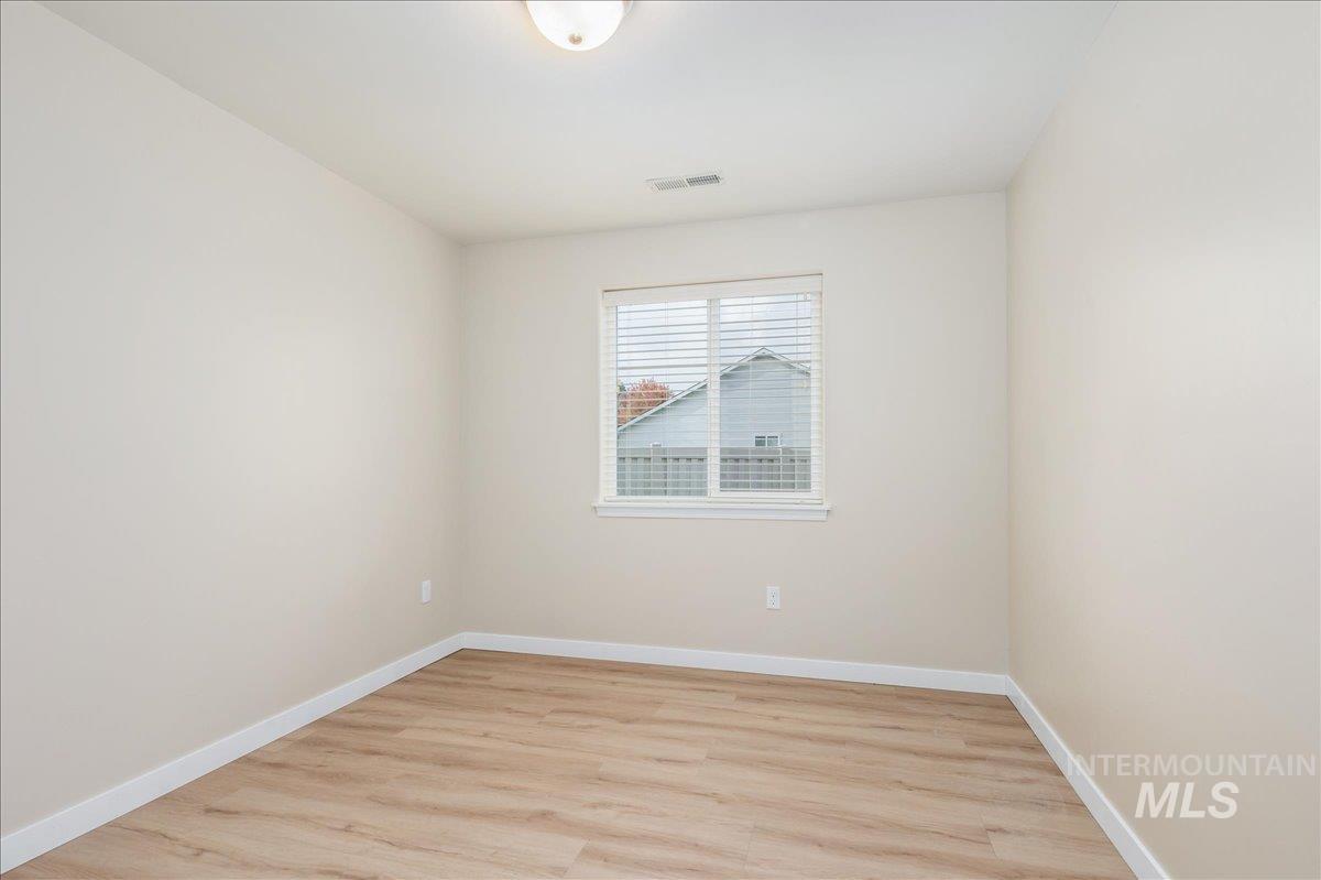Unfurnished room with light wood-style floors and baseboards