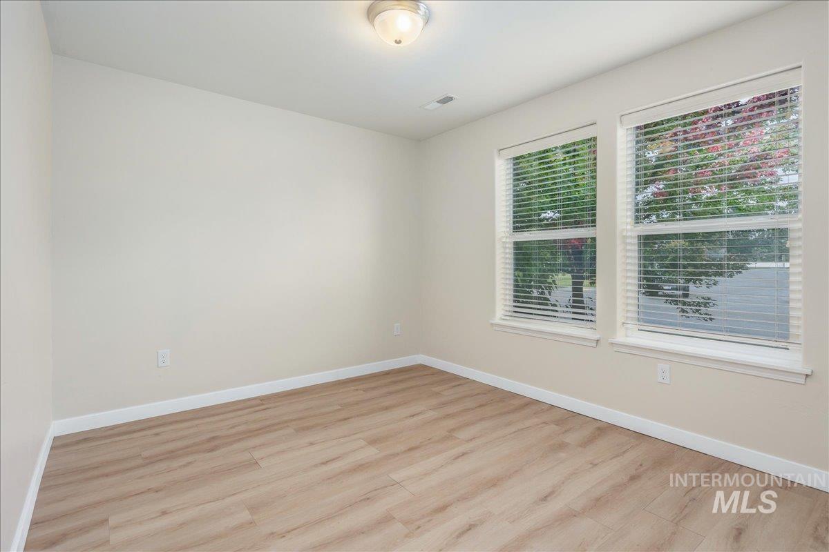Empty room with light wood-style flooring and baseboards