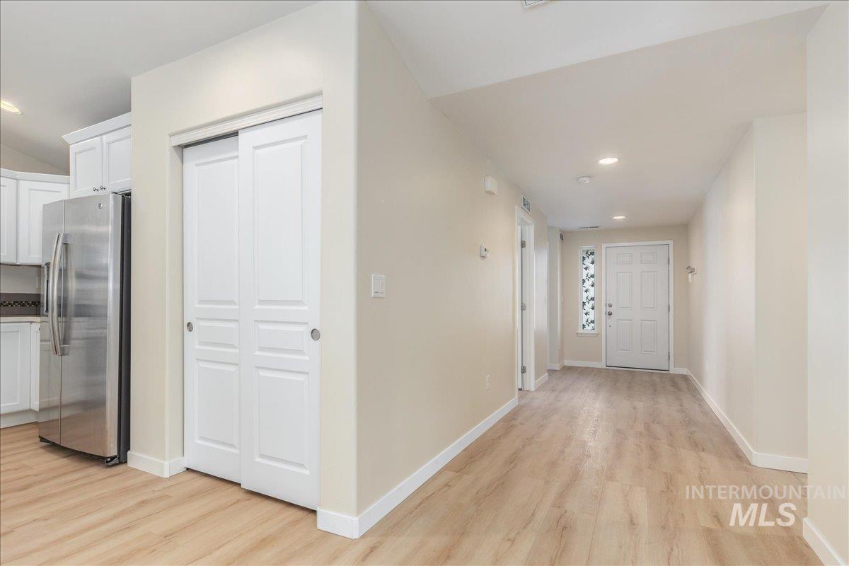 Hallway with recessed lighting and light wood-style floors