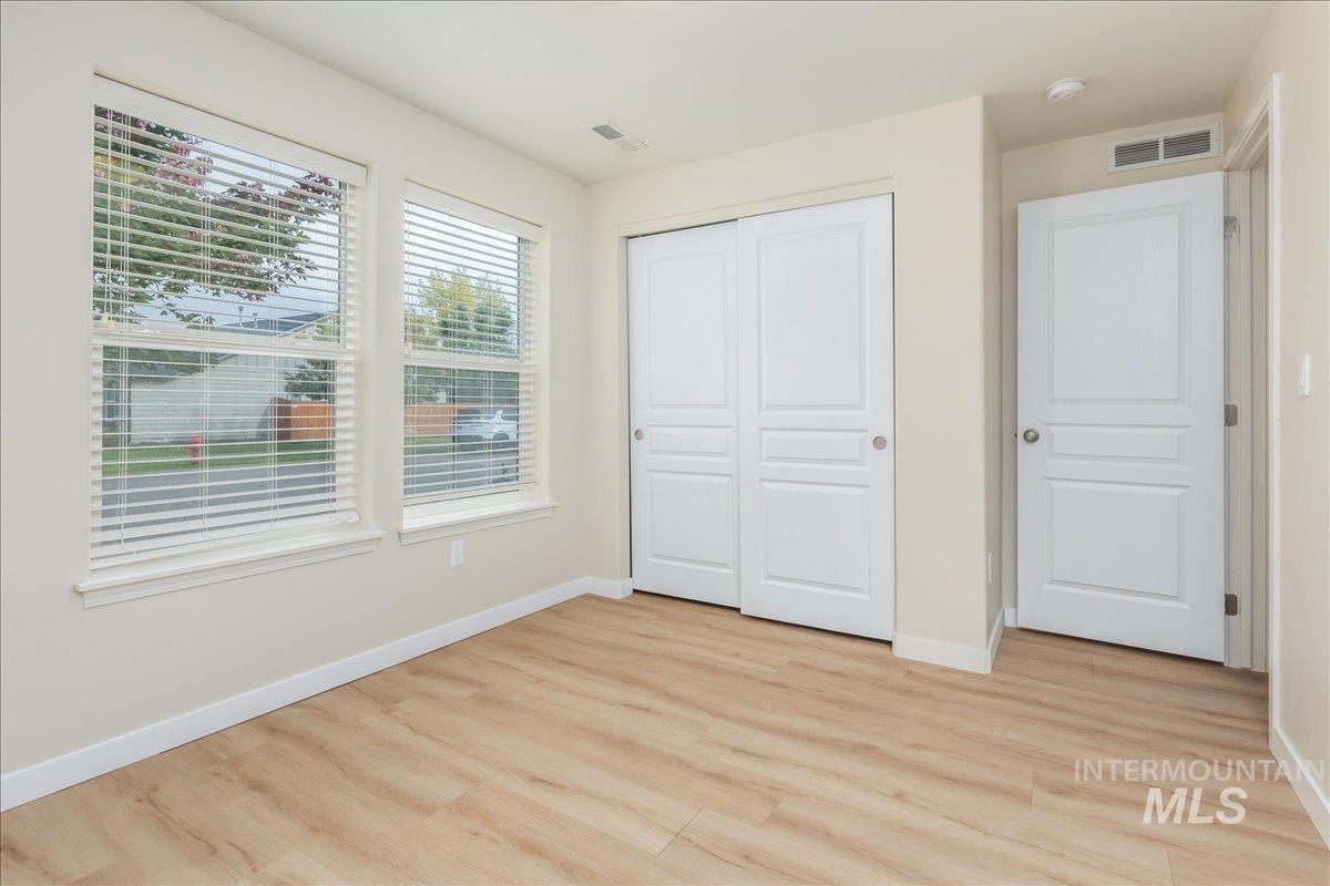Unfurnished bedroom featuring light wood-style flooring and a closet