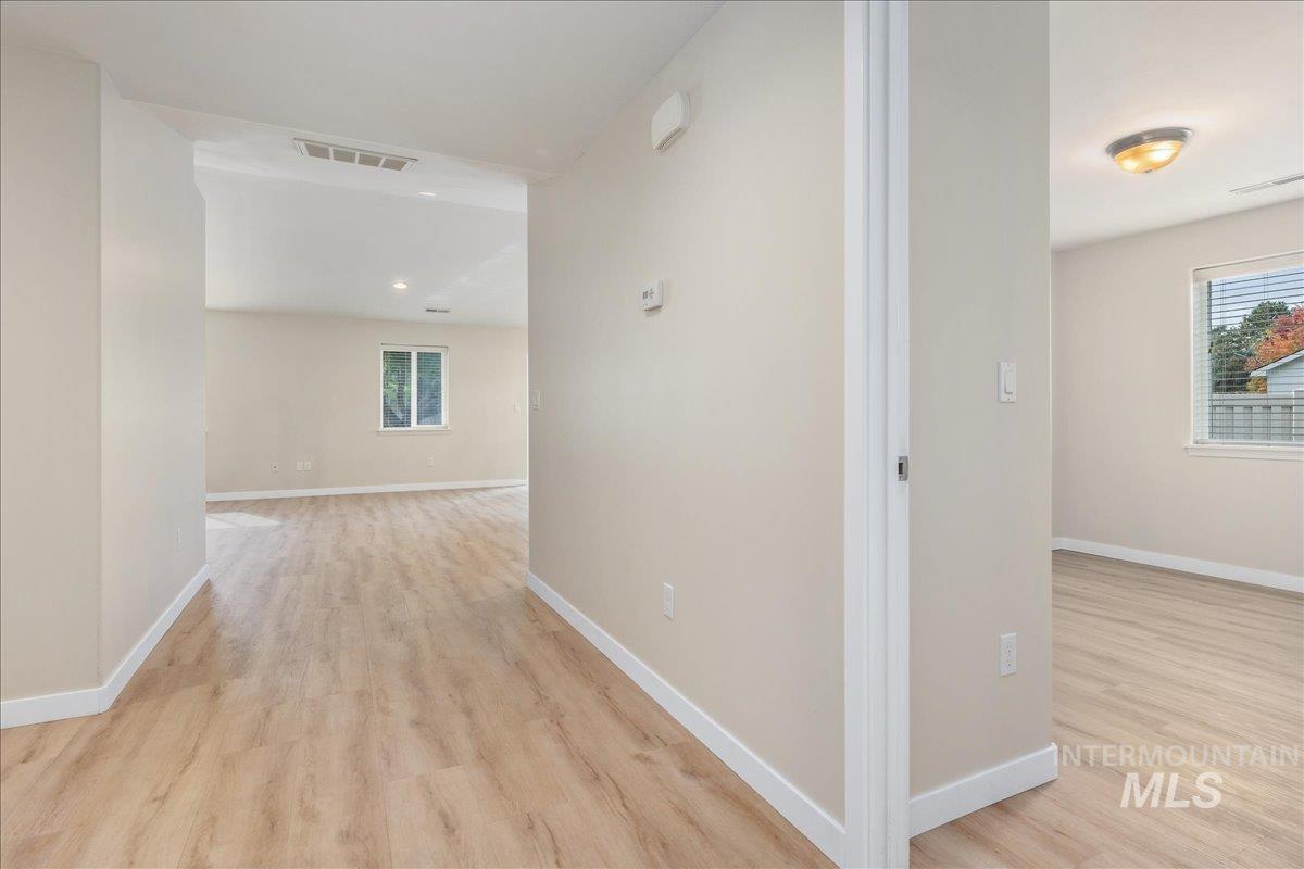 Corridor featuring light wood finished floors and healthy amount of natural light