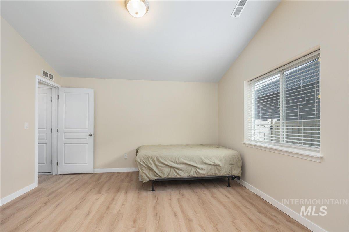Bedroom featuring lofted ceiling and light wood-style floors