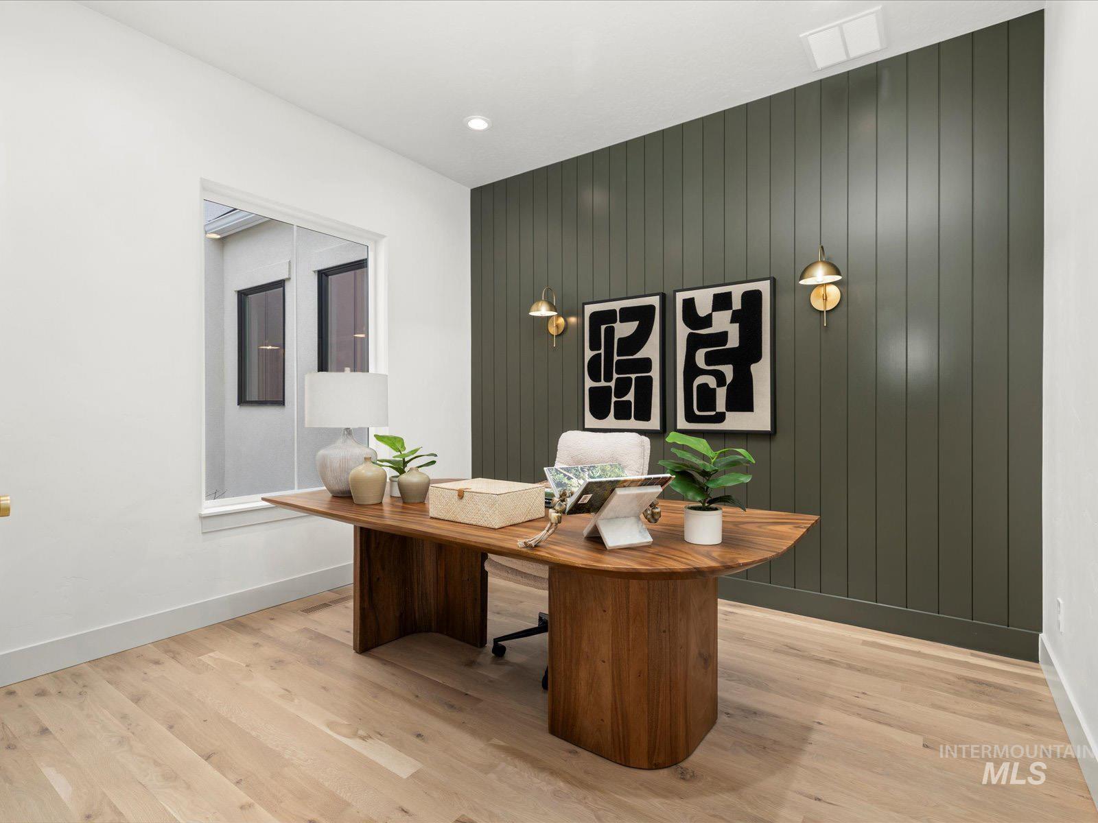 Office area with light wood-style flooring, wood walls, and recessed lighting