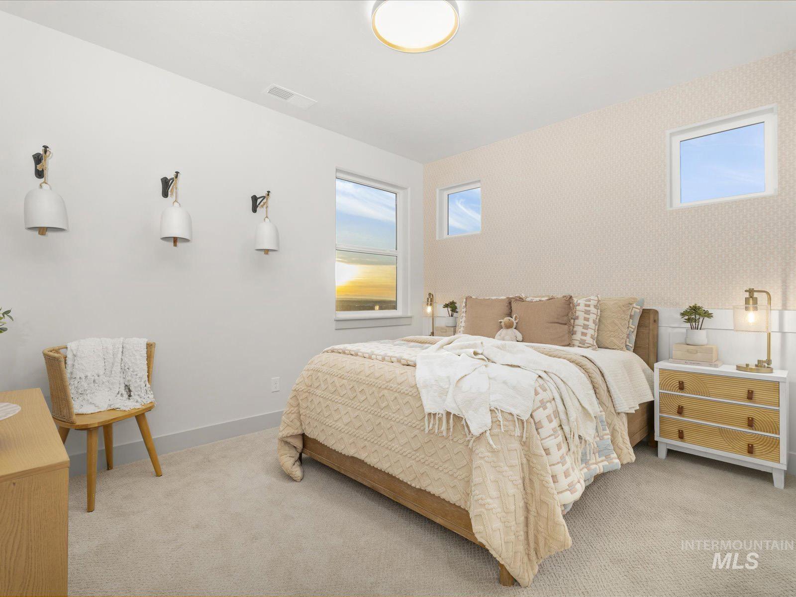 Bedroom with wallpapered walls and light carpet
