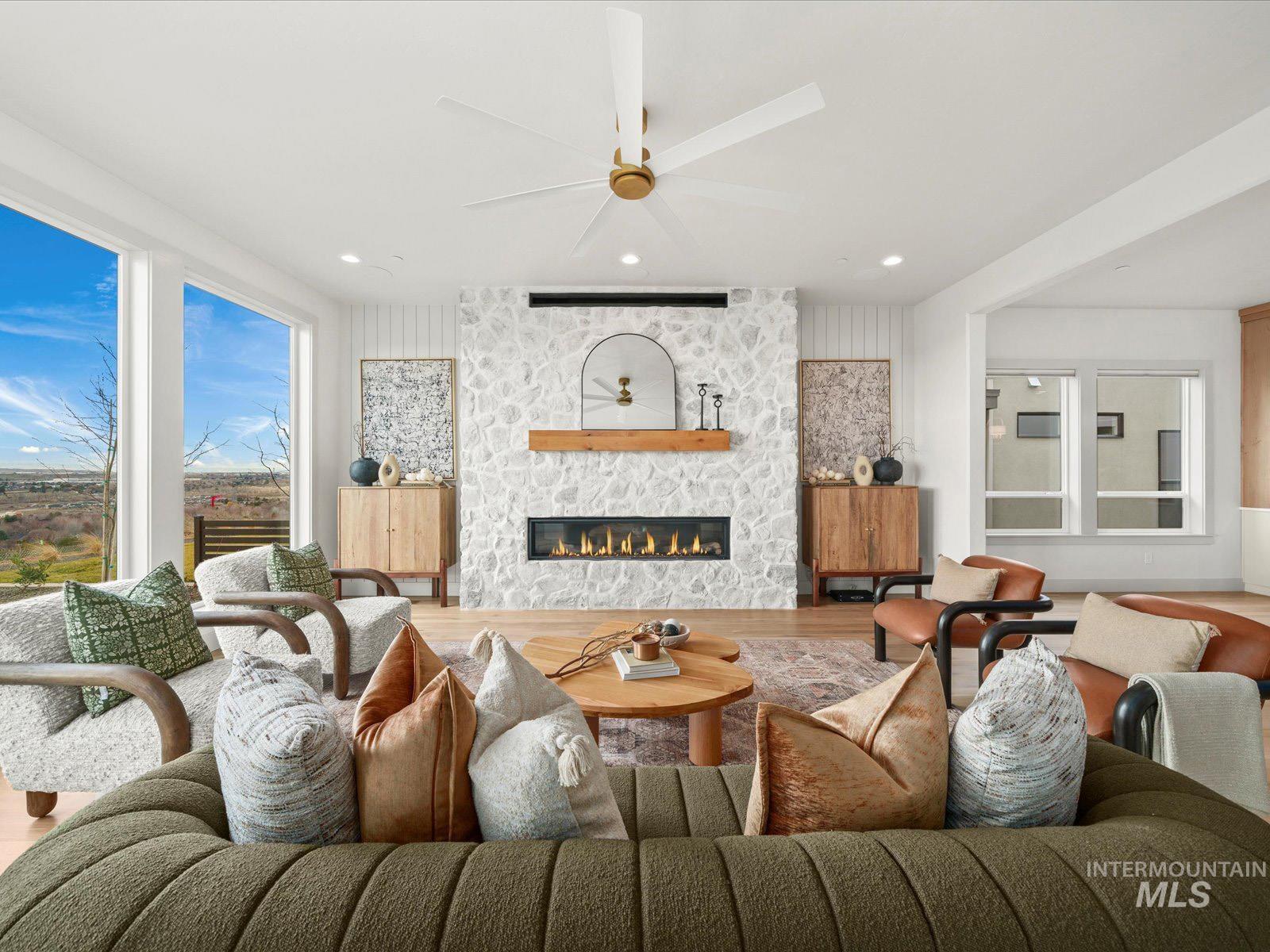 Living room with wood finished floors, a ceiling fan, a fireplace, and recessed lighting