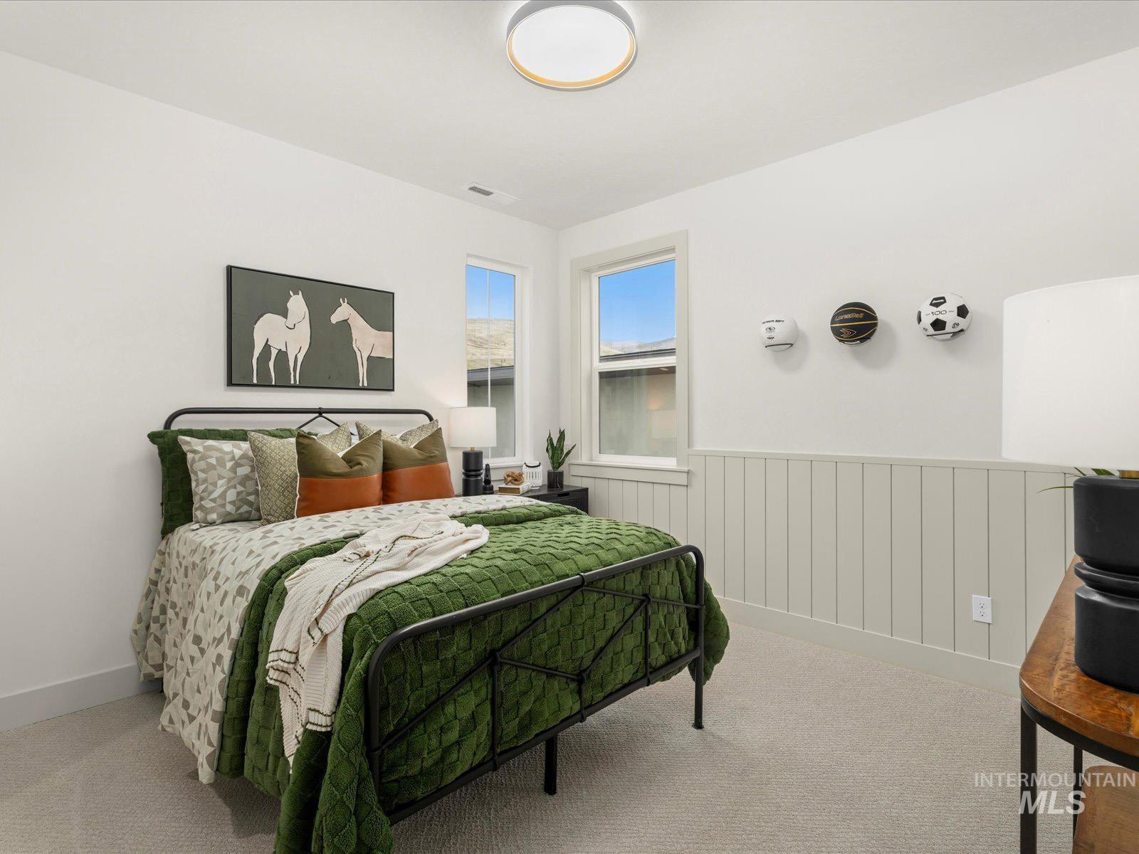 Bedroom featuring carpet floors and wainscoting