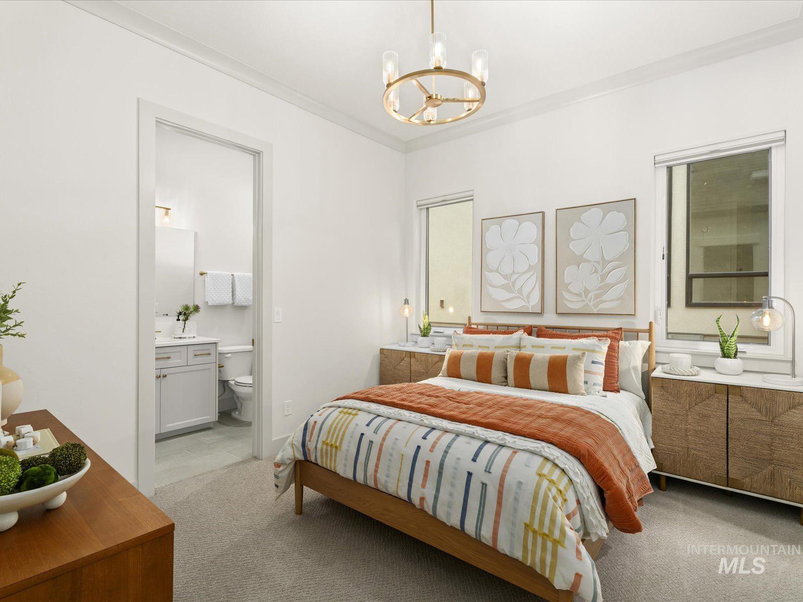 Bedroom with hanging lights, light carpet, and ornamental molding