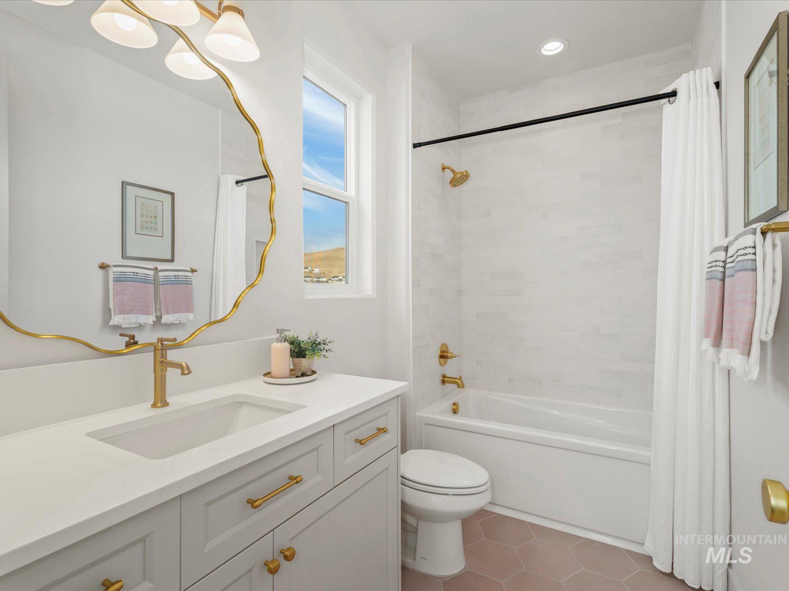 Full bath featuring vanity, light tile patterned floors, and shower / tub combo