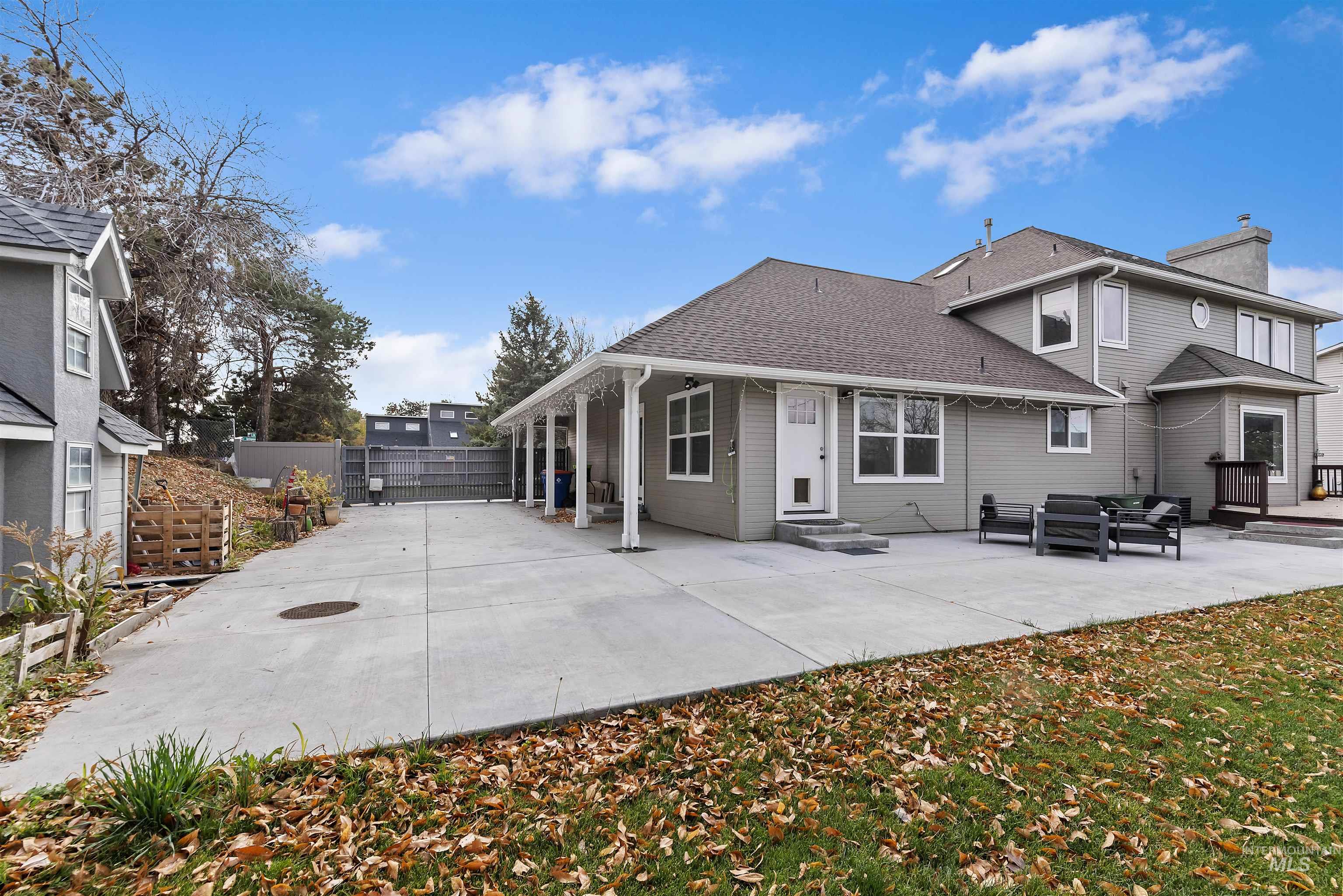 Back of house featuring a patio, an outdoor hangout area, a chimney, and roof with shingles