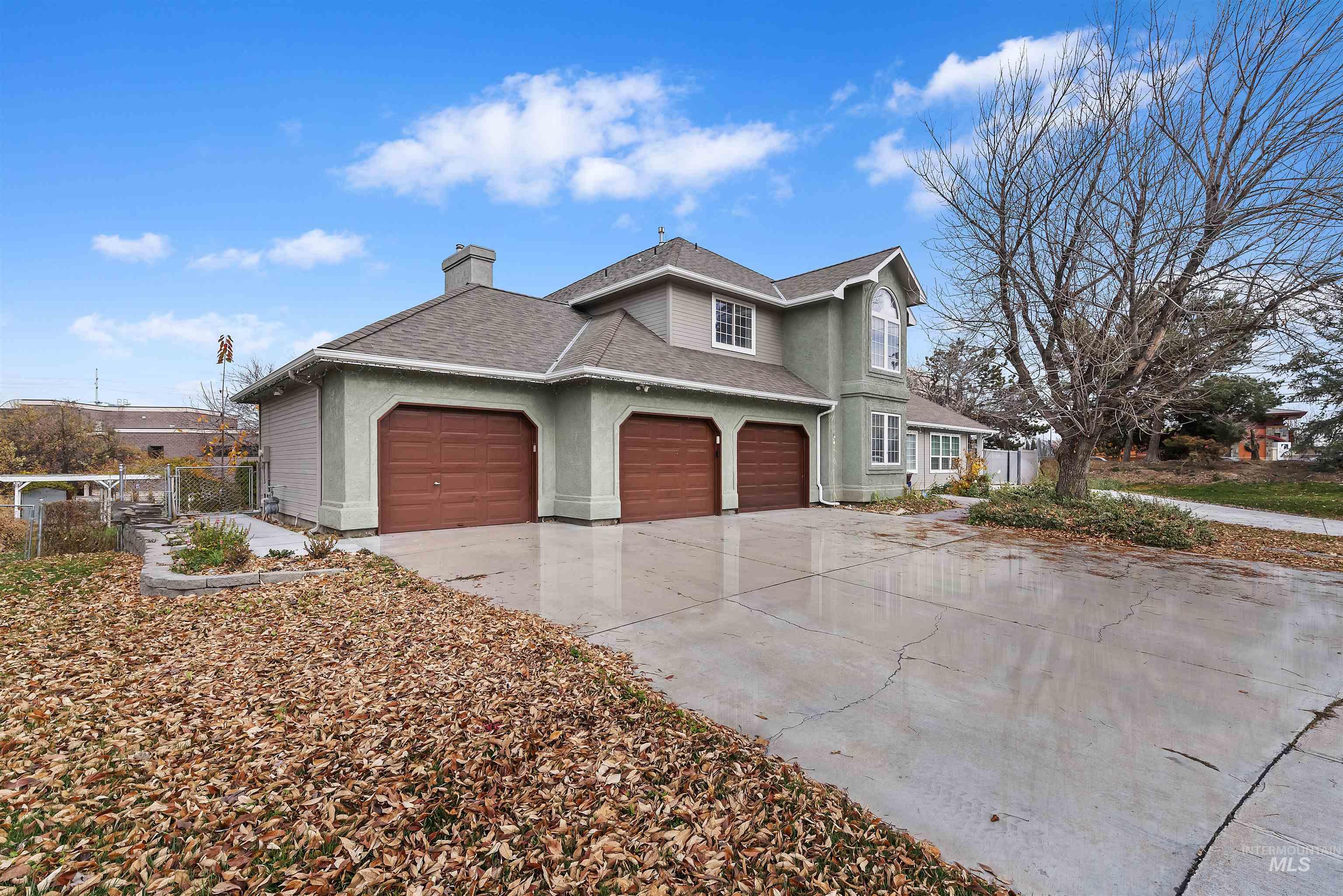 View of front facade with a chimney, driveway, a shingled roof, an attached garage, and stucco siding