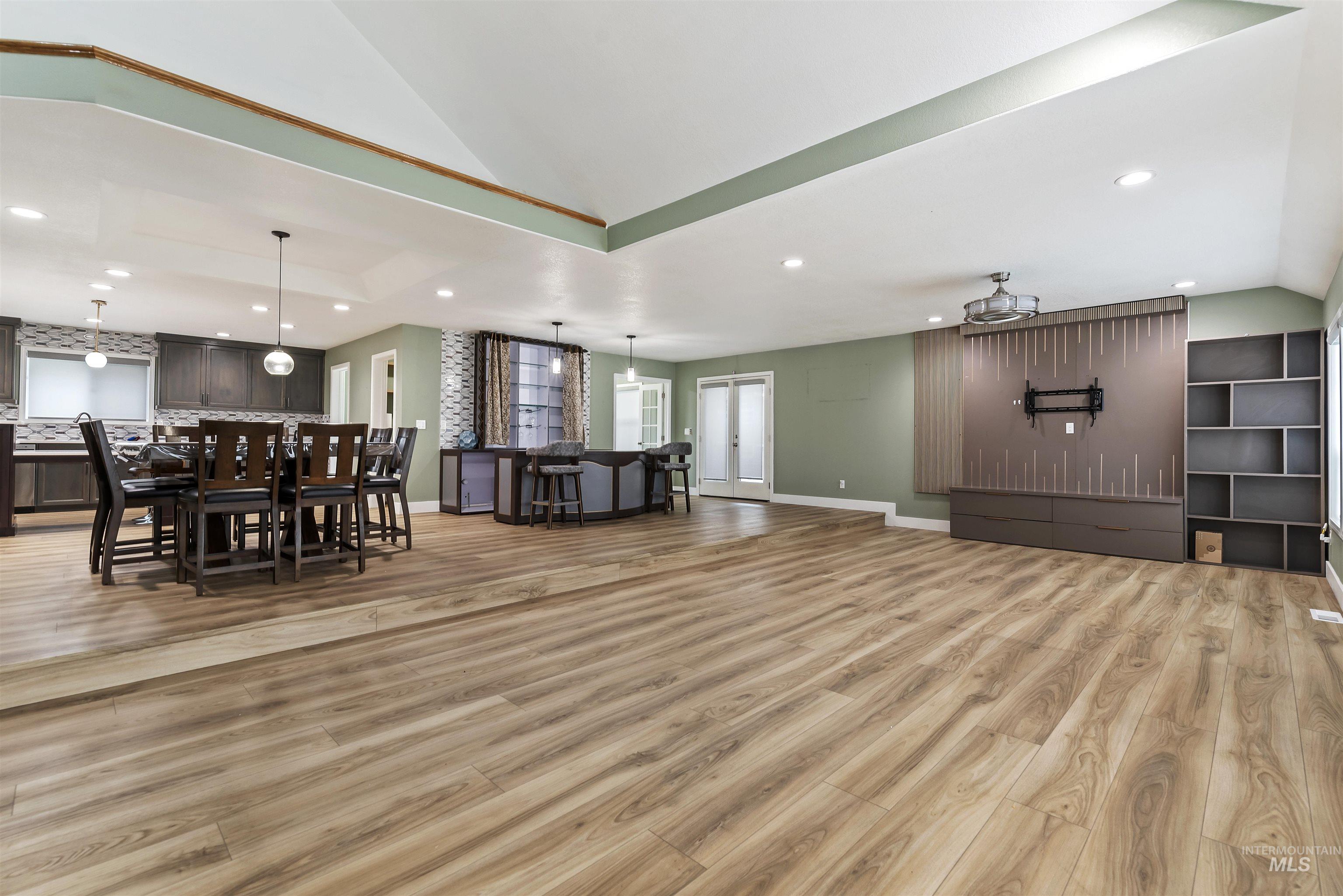 Living room with recessed lighting, lofted ceiling, and light wood finished floors
