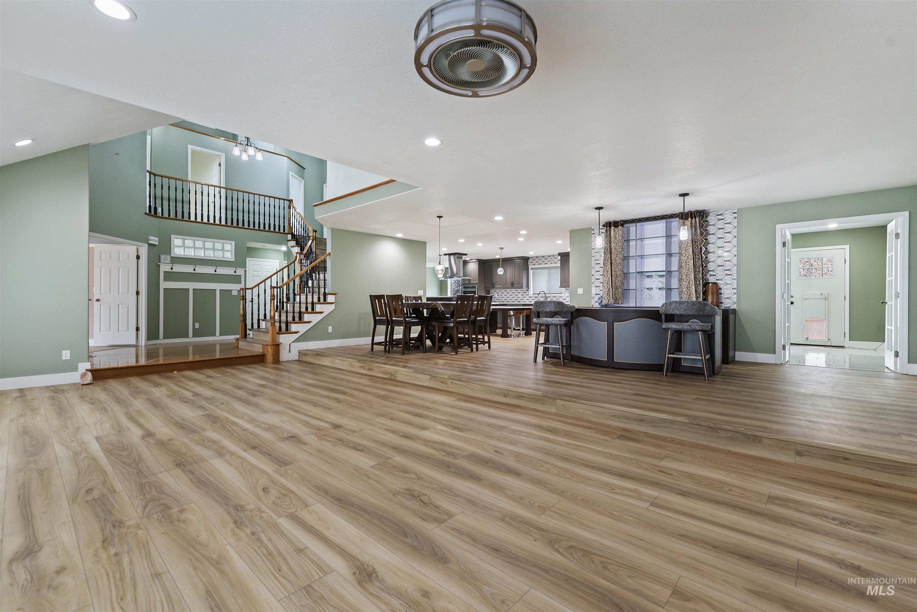 Living room featuring stairway, light wood finished floors, and recessed lighting