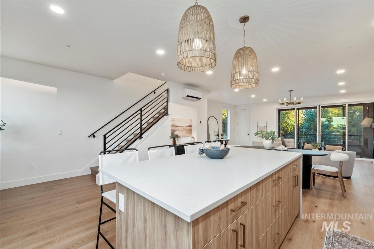 Kitchen featuring light brown cabinetry, modern cabinets, recessed lighting, light wood finished floors, and hanging light fixtures