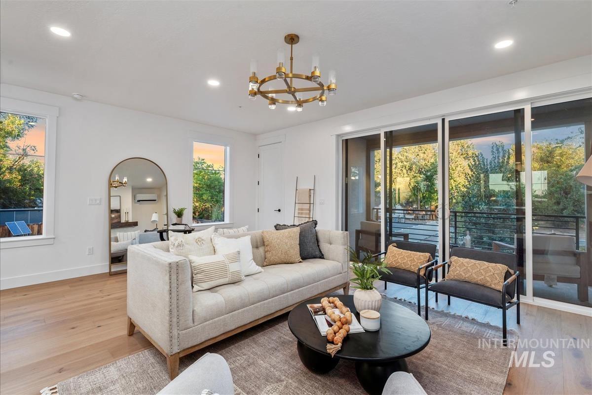 Living room with plenty of natural light, recessed lighting, a chandelier, and light wood-type flooring