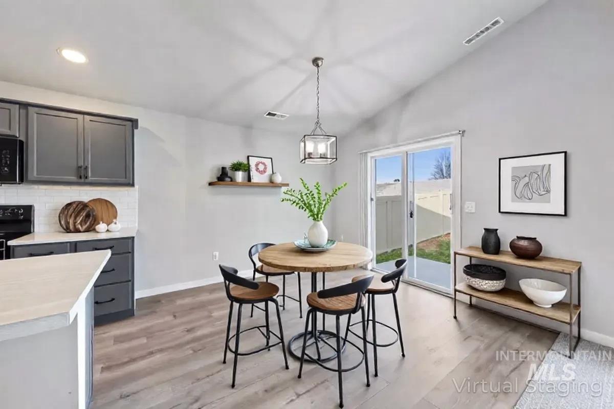 Dining space featuring lofted ceiling, light wood-type flooring, and a chandelier
