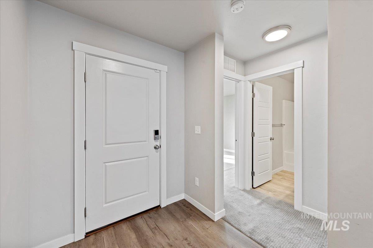 Foyer with light wood-style flooring and baseboards