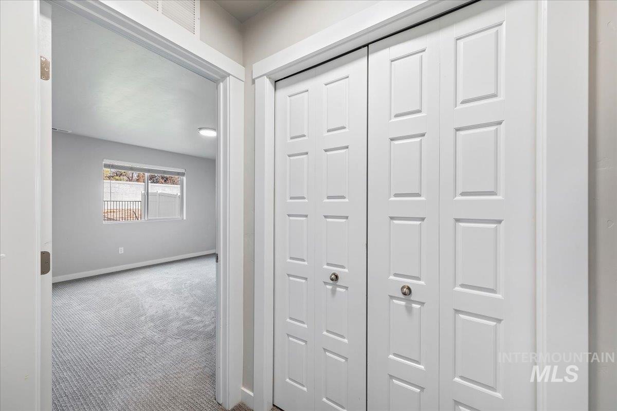 Hallway with carpet floors and baseboards