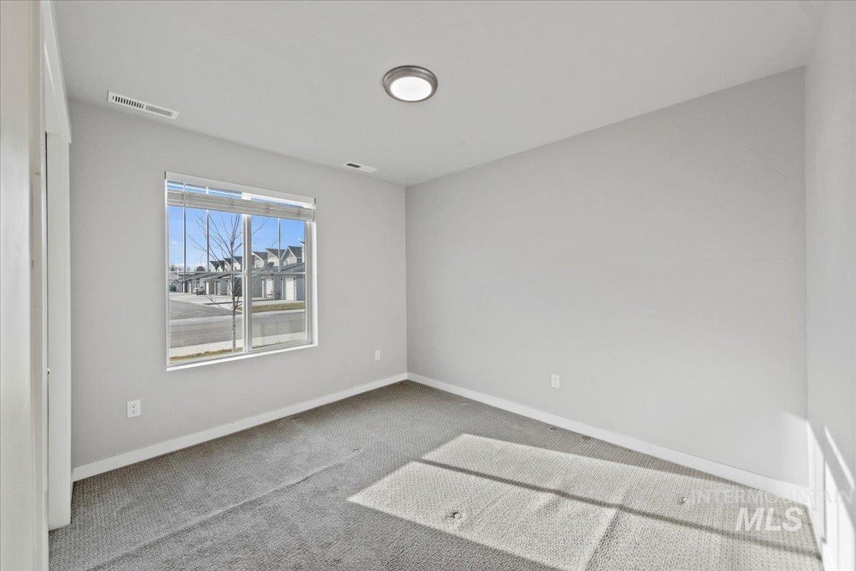 Carpeted spare room with baseboards