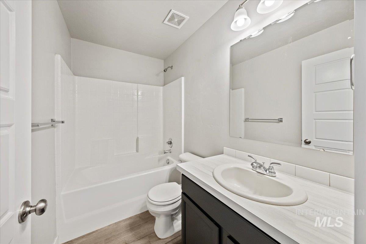 Full bathroom featuring bathing tub / shower combination, vanity, and light wood-type flooring