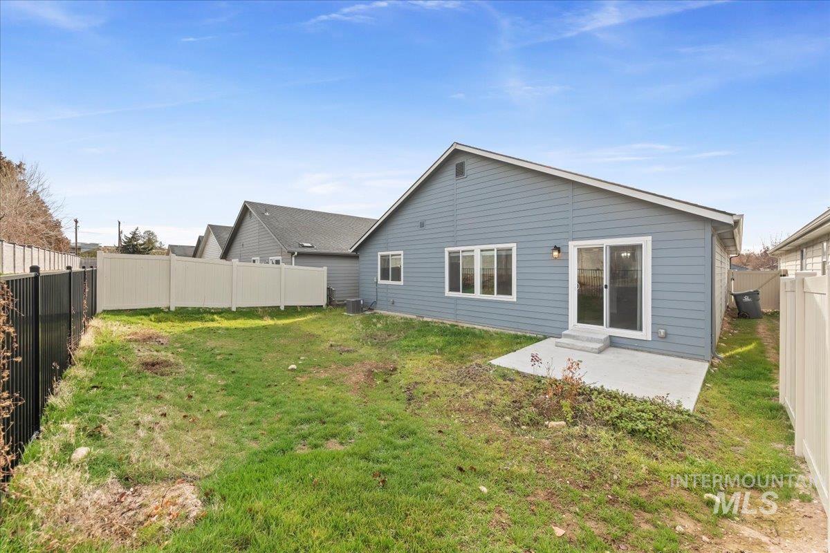Rear view of house with a fenced backyard and a patio area