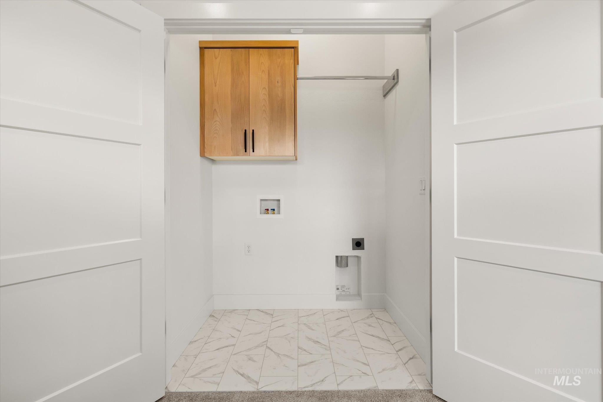 Laundry room with hookup for a washing machine, cabinet space, light marble finish flooring, and electric dryer hookup