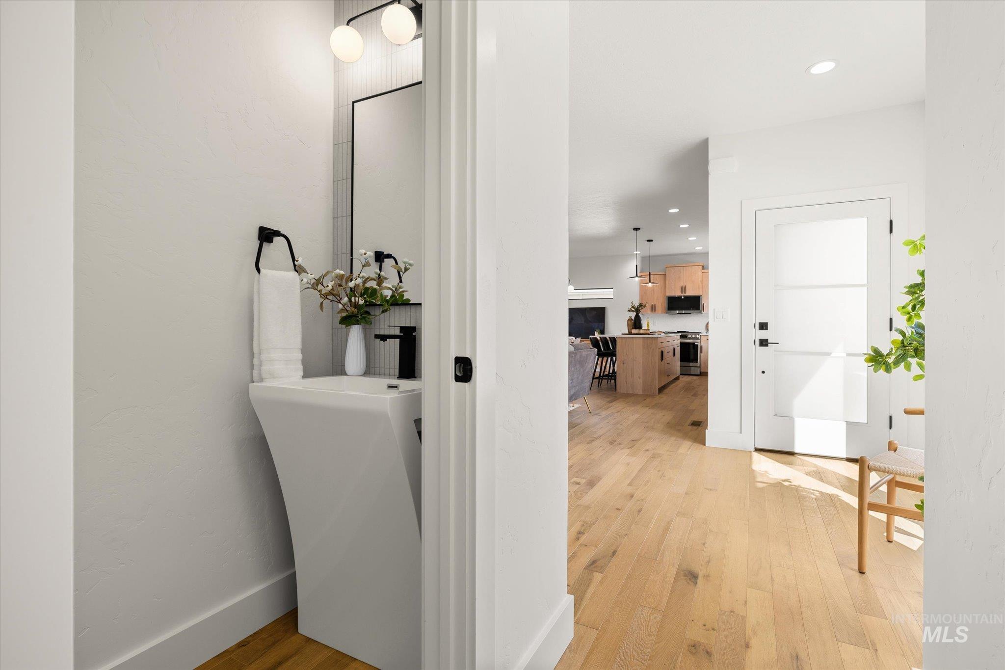 Corridor with light wood-style flooring and recessed lighting