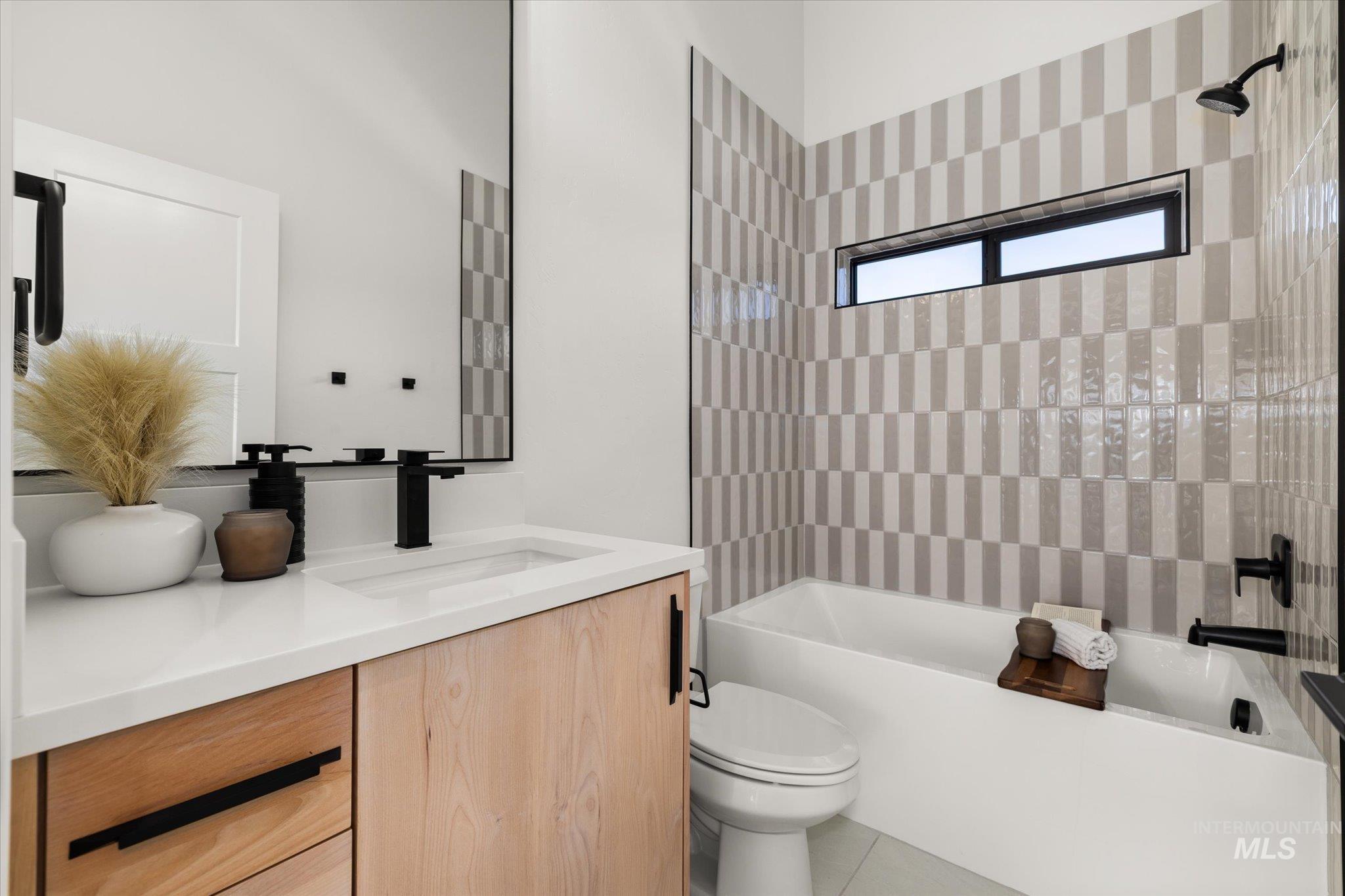 Bathroom featuring bathing tub / shower combination, vanity, and tile patterned floors