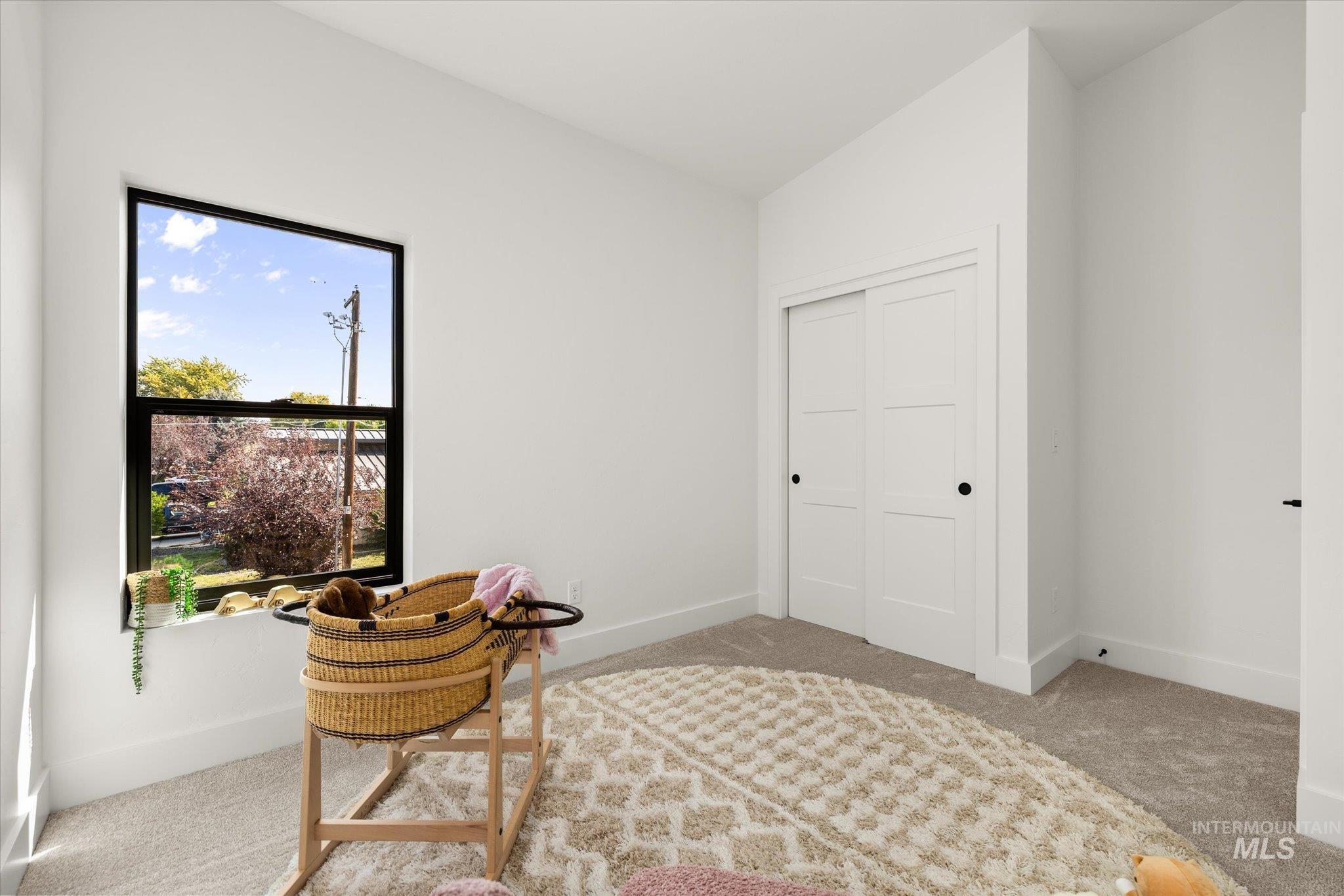 Living area with carpet floors and vaulted ceiling