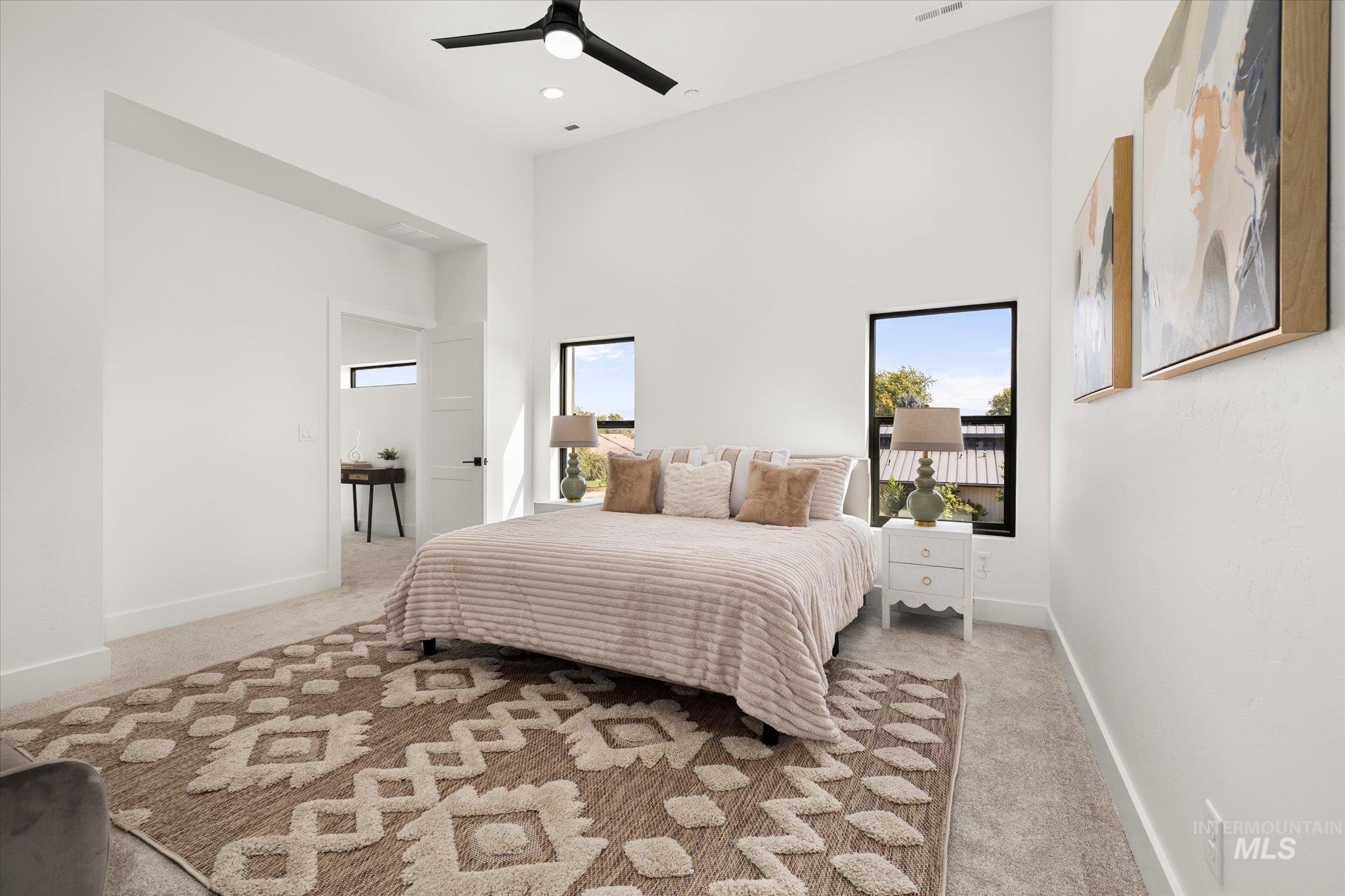 Bedroom featuring a high ceiling, light colored carpet, a ceiling fan, and recessed lighting