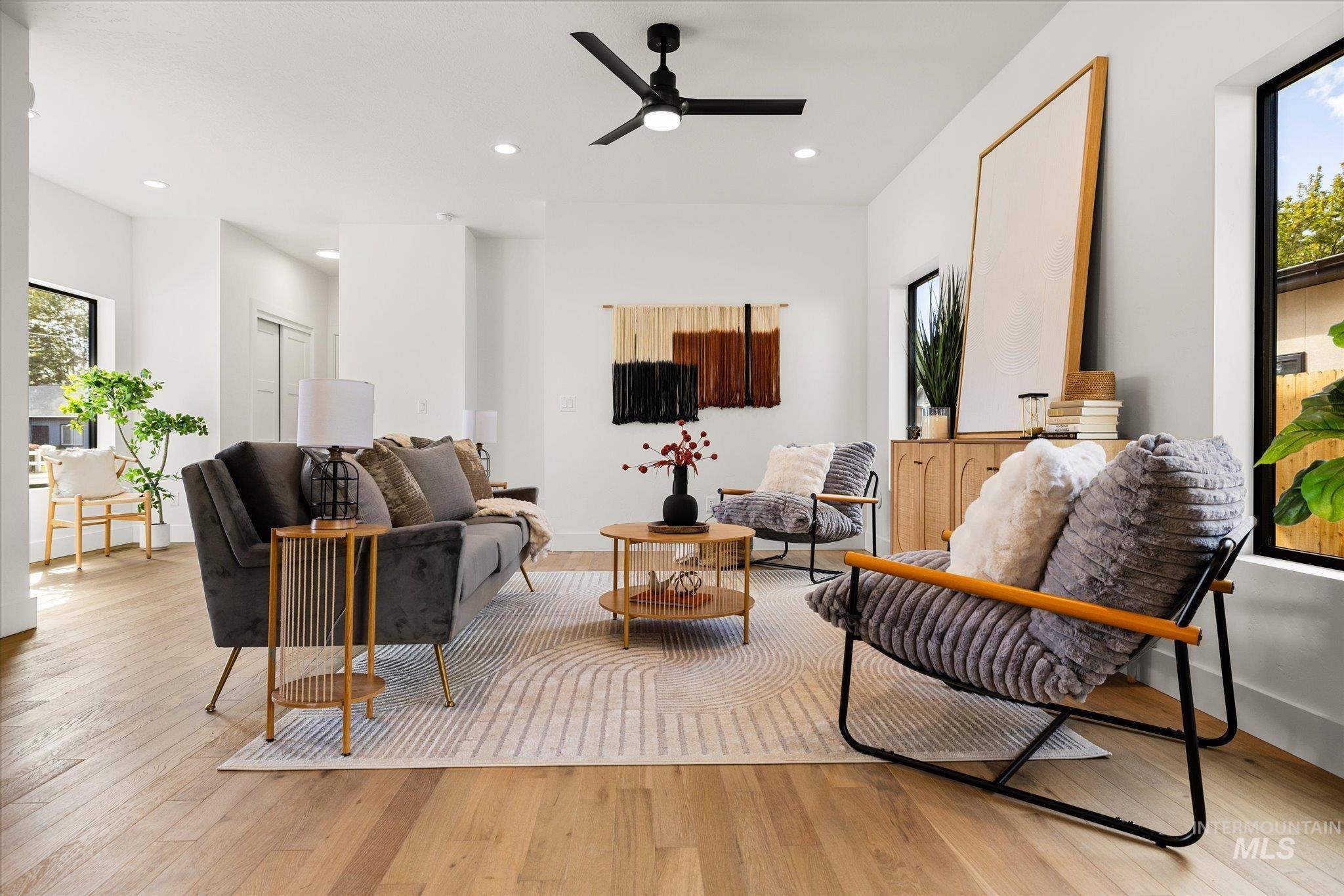 Living room with light wood-type flooring, recessed lighting, and a ceiling fan