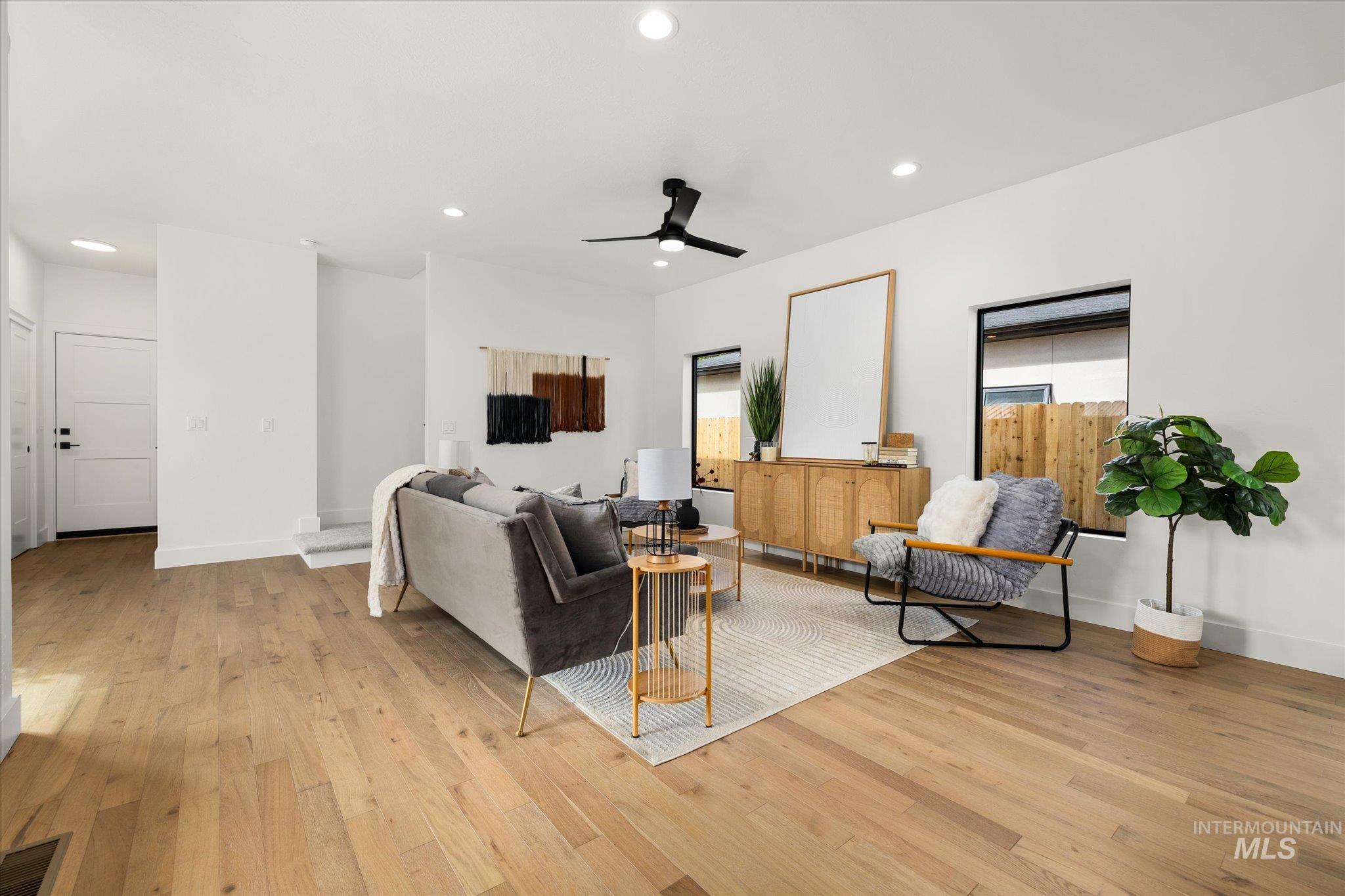 Living area with recessed lighting, light wood finished floors, and a ceiling fan