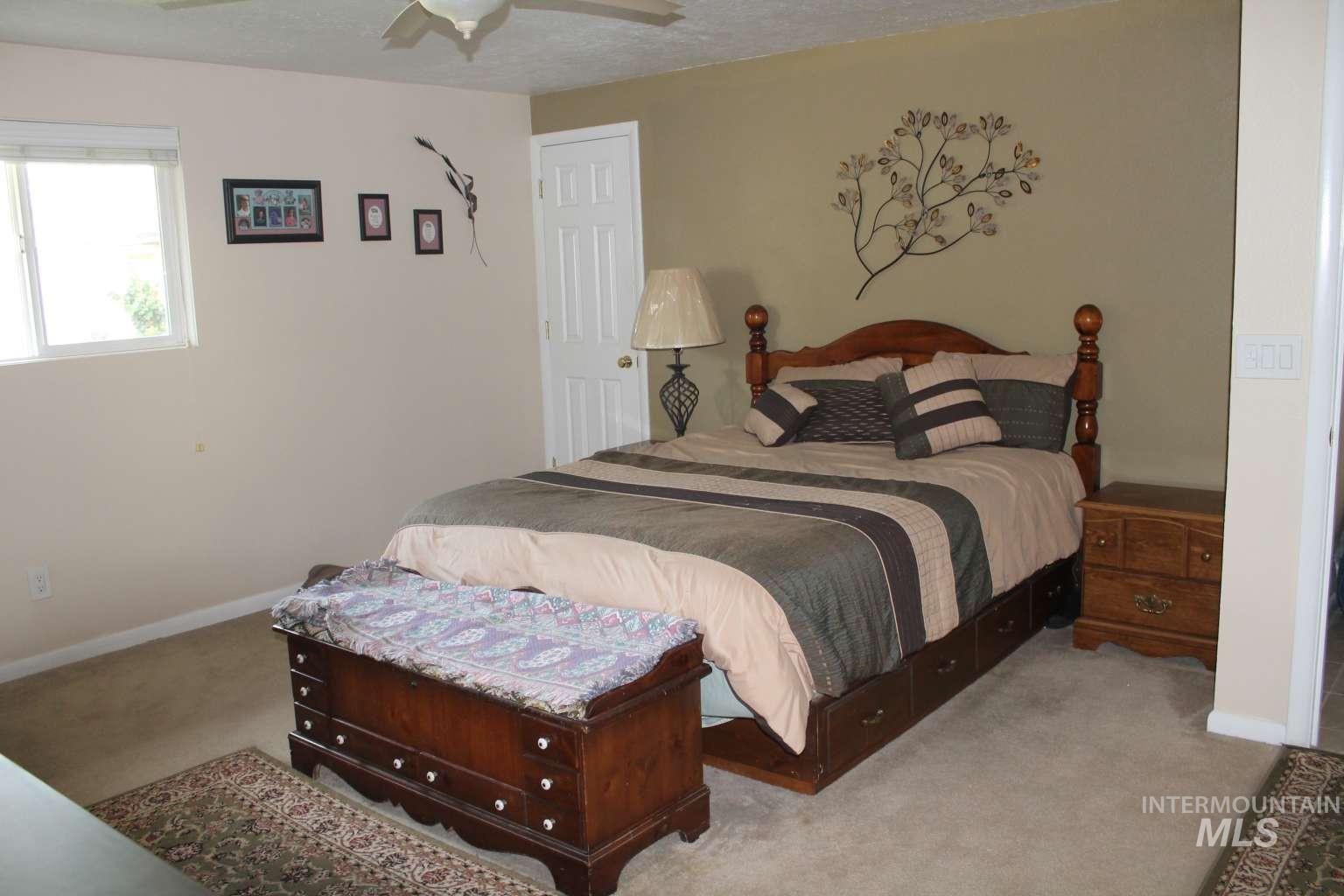 Bedroom featuring carpet floors, ceiling fan, and a textured ceiling