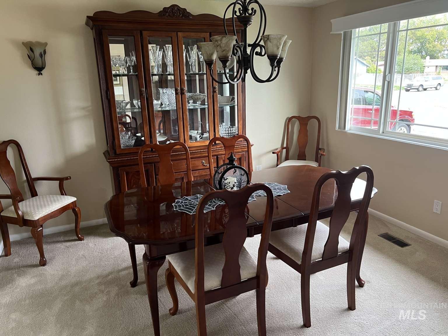 Dining area with light colored carpet and baseboards