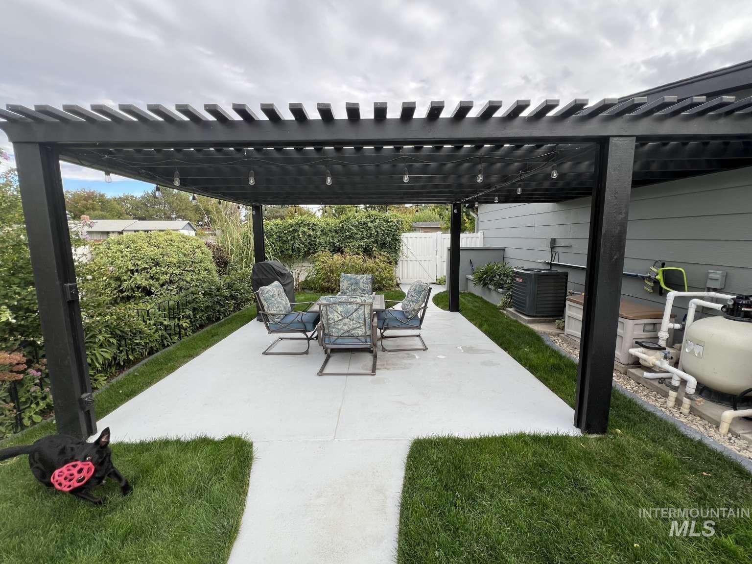 Fenced backyard with a pergola, a patio, and outdoor dining area